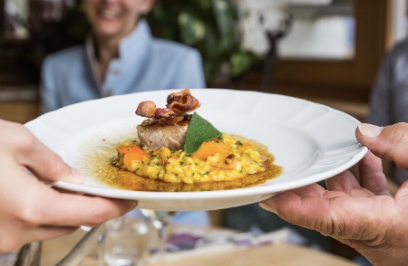 Schweinerücken auf Safran-Risotto, serviert vom Wirt